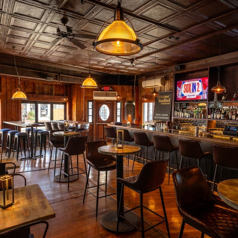 Inviting bar interior with wooden paneling, high-top seating, a full bar, and multiple large screen TVs.